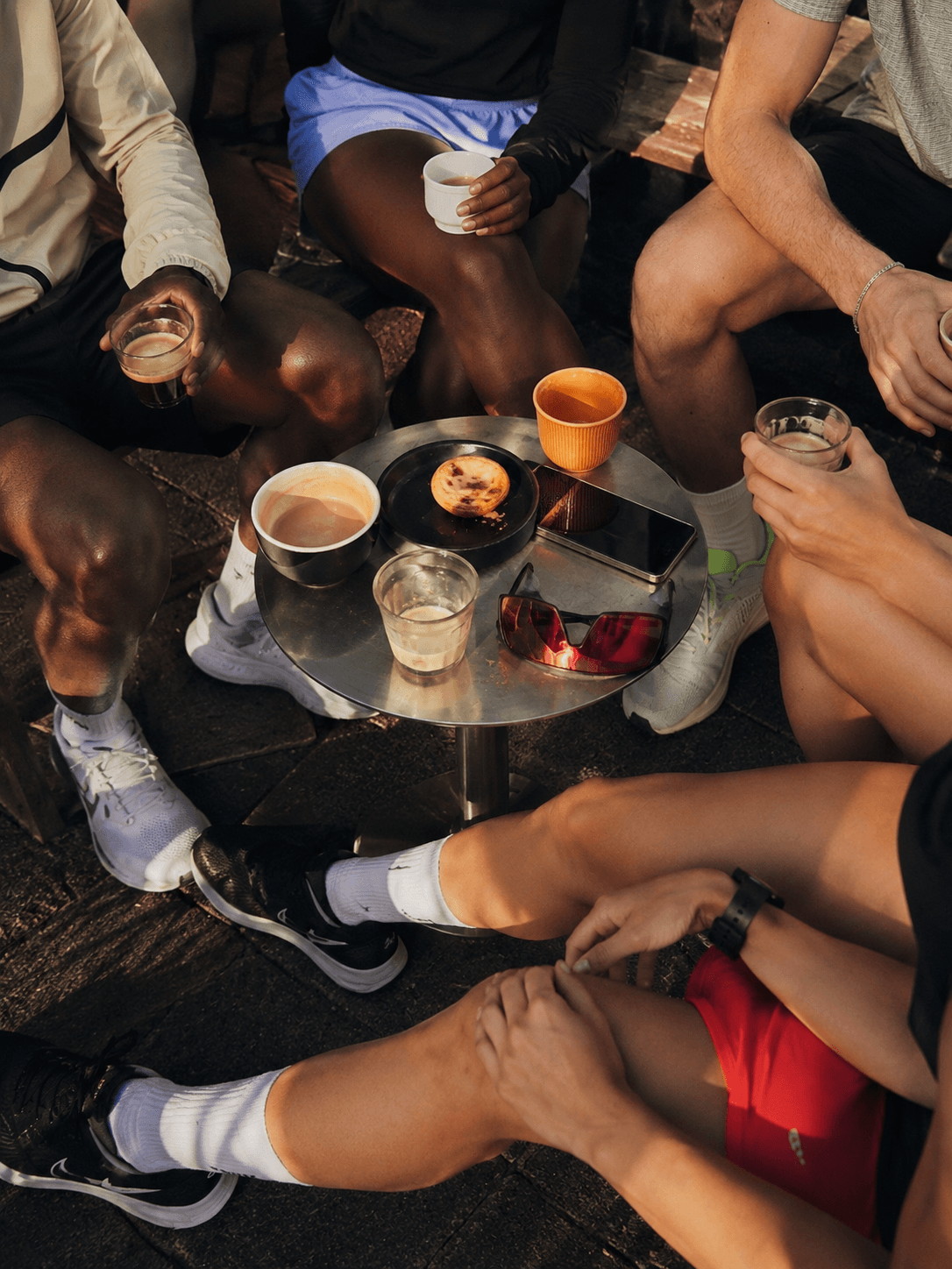 Coffee on a small table after a run, cups and conversation close together.